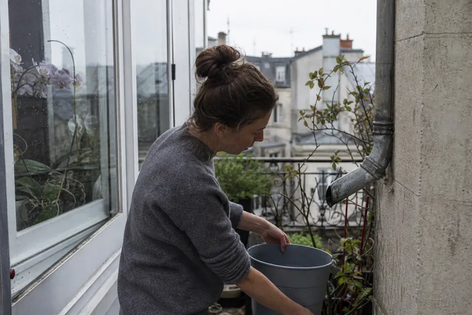 Récupération d’eau de pluie dans un seau sur un balcon pour arroser les orchidées